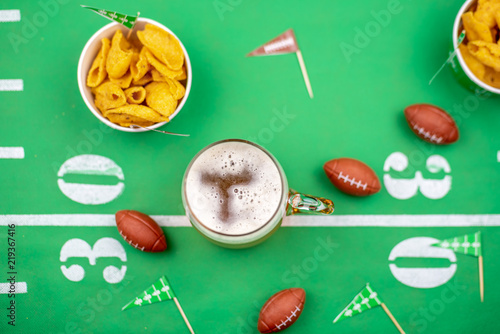 Obraz na płótnie closeup of mug of beer and football decorations on table for game day