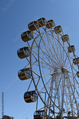 Big wheel in Novosibirsk, Russia. Gondolas, blue sky background