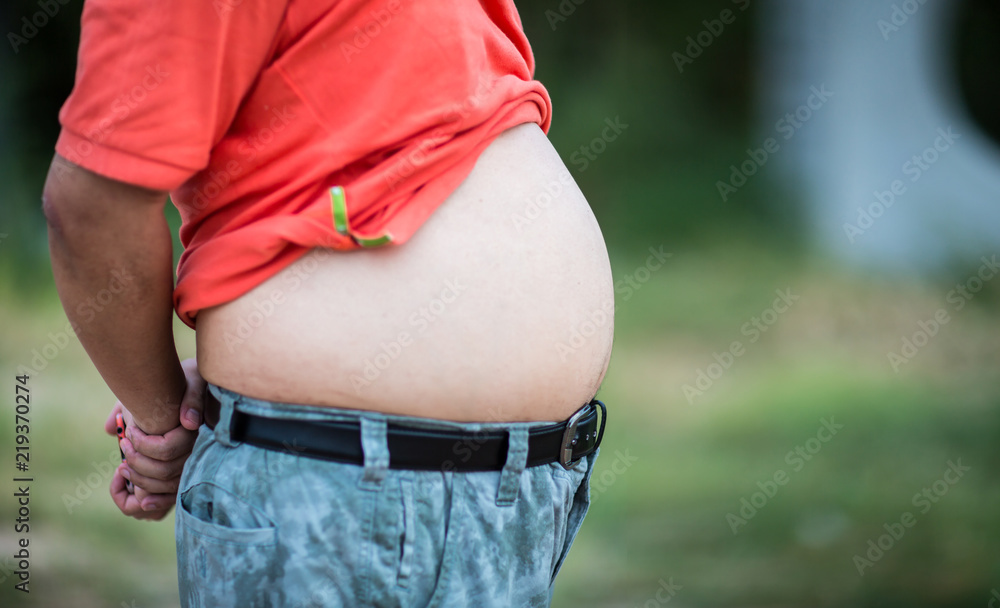 Asian fat guy wearing T-shirt, color pants, nature background. close up On pot-bellied of overweight man , big stomach of fat man Stock Photo | Adobe Stock