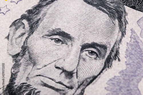 Close up view Portrait of Abraham Lincoln on the one five dollar bill. Background of the money. 5 dollar bill with Abraham Lincoln eyes macro shot. Money background. Face portrait