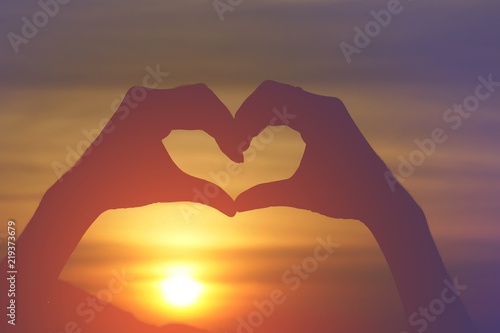 silhouette hand gesture feeling love during sunset