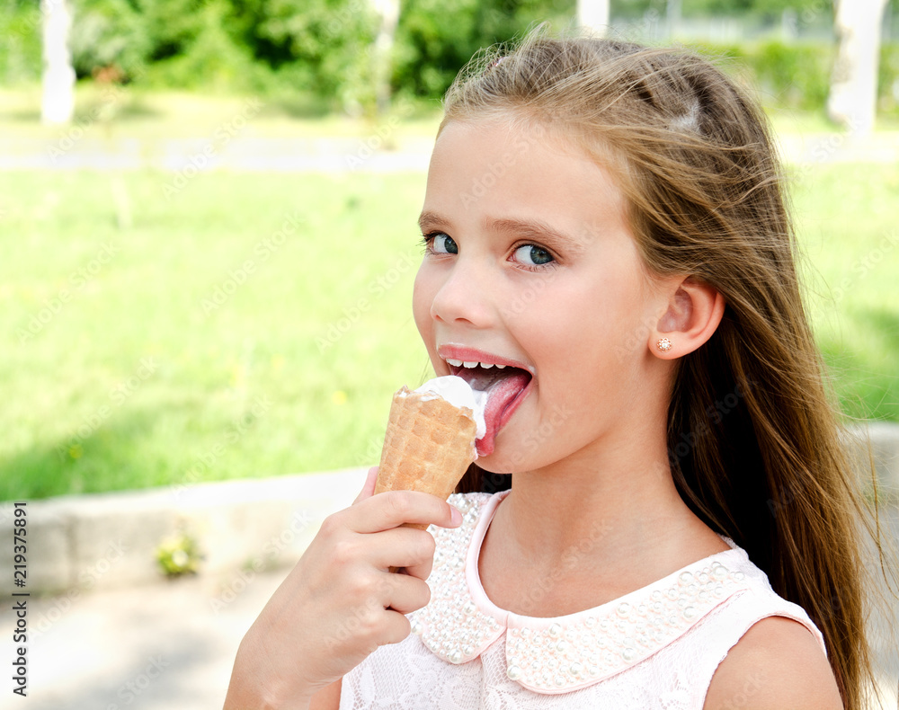 Cute happy smiling little girl child eating an ice cream outdoor Cute happy smiling little girl child eating an ice cream outdoor