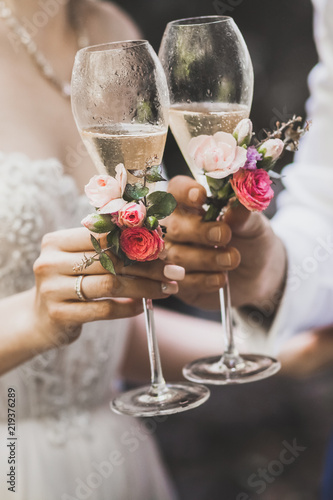 Two decorated champagne glasses in couple hands together