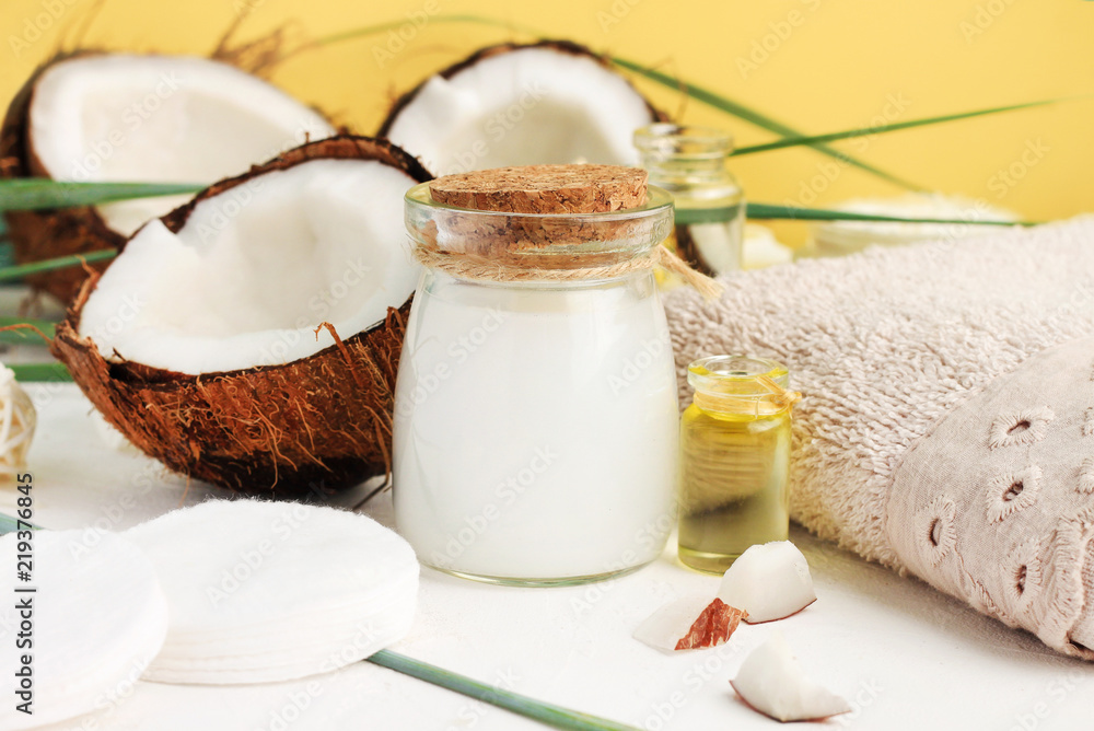 Fresh homemade coconut milk in glass jar, oil and nut for skin treatment, hair care, bathroom towel. Home spa with holistic coco nut products, healing lotion recipe. Safe, natural, aromatic. Fresh homemade coconut milk in glass jar, oil and nut for skin treatment, hair care, bathroom towel. Home spa with holistic coco nut products, healing lotion recipe. Safe, natural, aromatic.