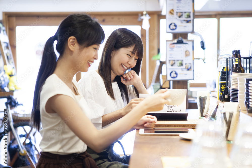 カフェのカウンターで楽しそうに会話する女性たち カフェのカウンターで楽しそうに会話する女性たち