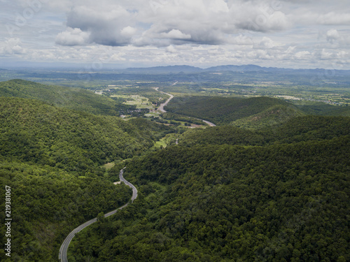 Aerial view of countryside road passing through the lush greenery and foliage tropical rain forest mountain landscape in the Northern Thailand