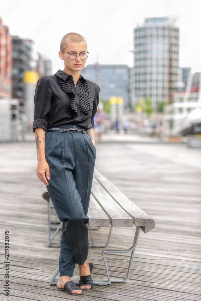 Business-Frau in der Hafencity lehnt an der Bank