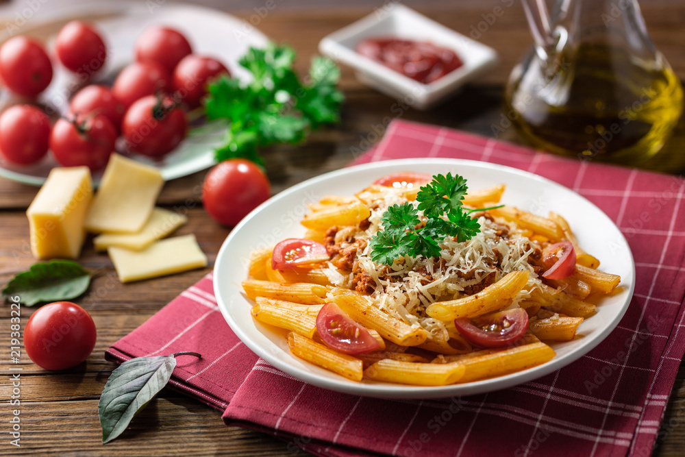 Pasta bolognese with tomato sauce and minced meat, grated parmesan cheese and fresh basil - homemade healthy italian pasta on rustic wooden background. Pasta bolognese with tomato sauce and minced meat, grated parmesan cheese and fresh basil - homemade healthy italian pasta on rustic wooden background.