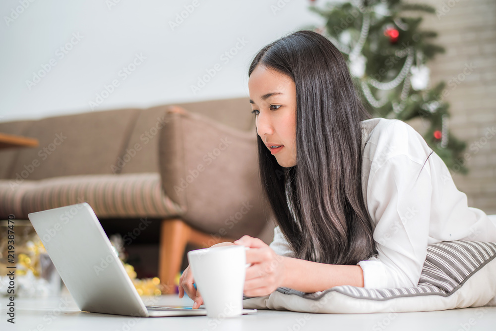 Happy young Asian business woman using laptop by laying on the floor at home, business online shopping. Happy young Asian business woman using laptop by laying on the floor at home, business online shopping.