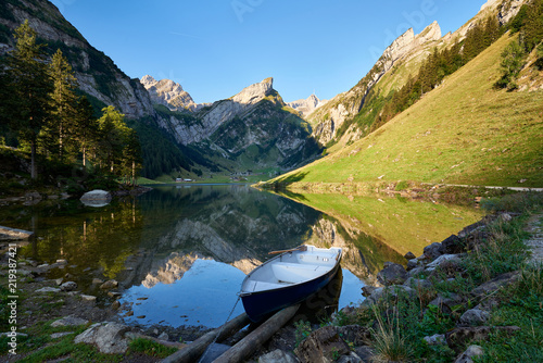 Blick auf Alpsteinmassiv mit Säntis, Spiegelung der Berge im Seealpsee, Ruderboot, Seeufer, Bergwald, blauer Himmel