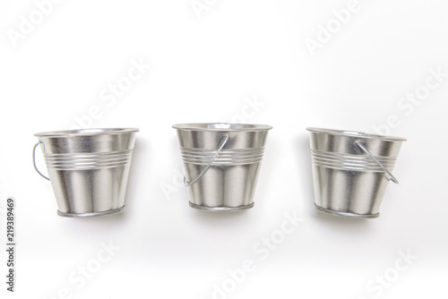 Three small empty metal bucket on white background. photo