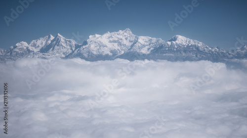 The Himalayas as seen from an airplane in Nepal. Layer of clouds beneath the mountain tops.