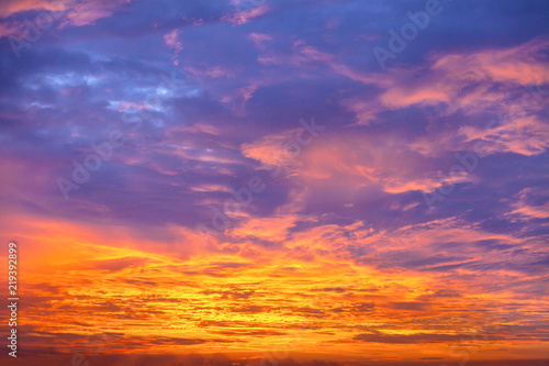 Sunset sky background. Dramatic sunset sky with evening sky clouds lit by bright sunlight - natural city sunset sky landscape view.