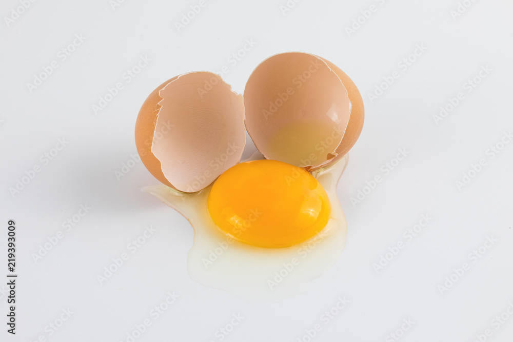 Egg yolk with broken egg shell on white background Egg yolk with broken egg shell on white background