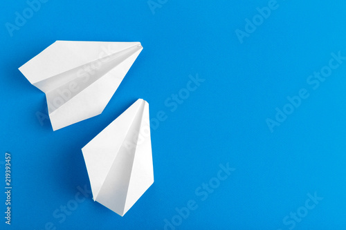 Flat lay of a paper plane on pastel blue color background