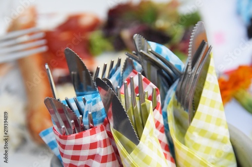 Weinglas und Weinflasche mit herabfallenden Tropfen beim Einschenken auf einem Gartentisch