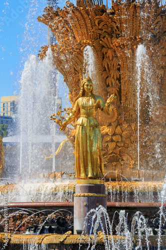 Gilded bronze girl against golden sheaf of wheat with technical hemp and sunflowers symbolizing Republic of USSR in fountain Friendship of peoples on VDNH in Moscow