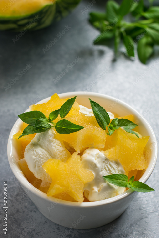 Stars of a ripe watermelon and ice cream in a white cup for dessert, mint and a cut watermelon in the background Stars of a ripe watermelon and ice cream in a white cup for dessert, mint and a cut watermelon in the background