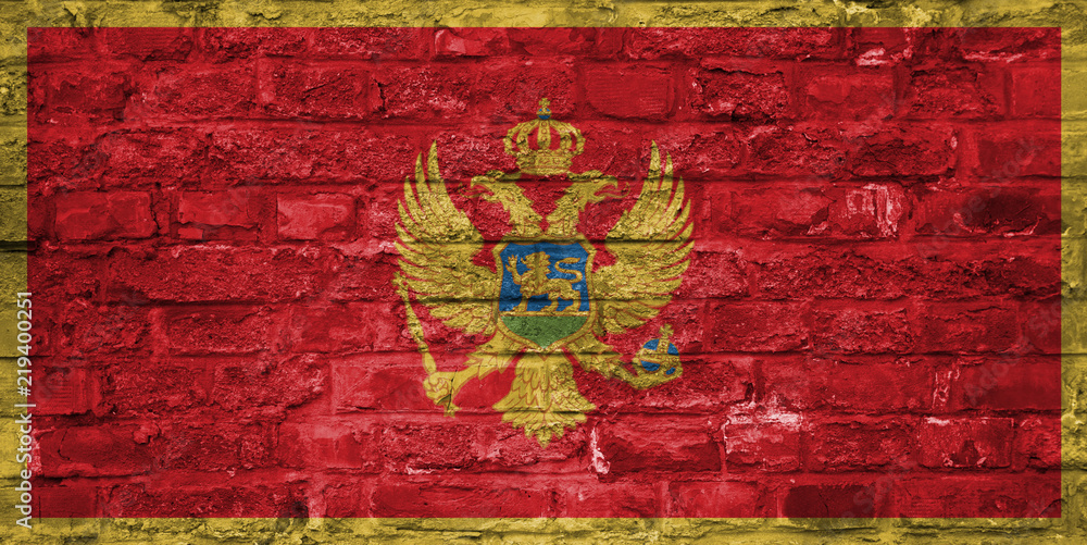 Flag of Montenegro over an old brick wall background, surface