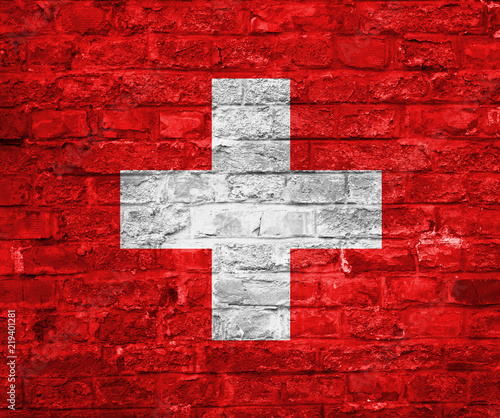 Flag of Switzerland over an old brick wall background, surface