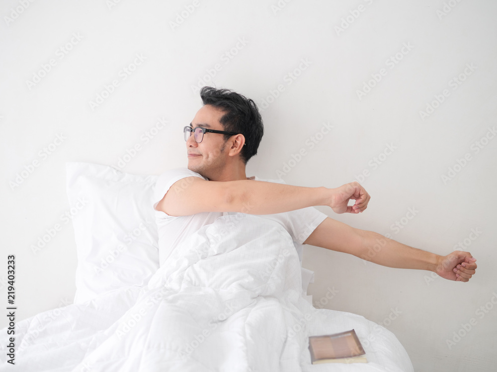 Happy Asian man stretching himself on bed, lifestyle concept. Happy Asian man stretching himself on bed, lifestyle concept.