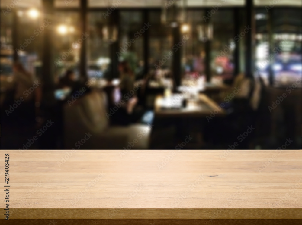 Wood table with blured background cafe , for your photo montage or product display. Space for placing items on the table.