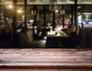 Wood table with blured background cafe , for your photo montage or product display. Space for placing items on the table.