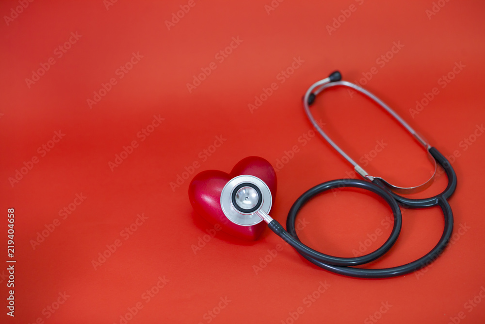 Stethoscope around a red rubber heart on a red background; concept of health healthy heart or cardio examination. Stethoscope around a red rubber heart on a red background; concept of health healthy heart or cardio examination.