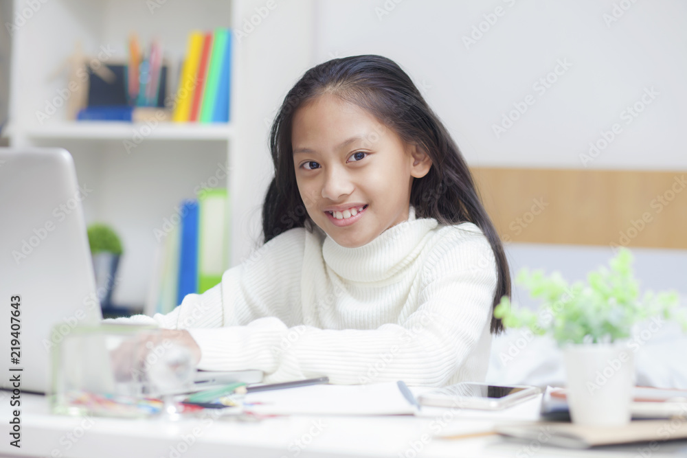 Asian female use laptop computer to work from home.Girl sitdown at living room.working online lifestyle.Social distancing for stay at home.