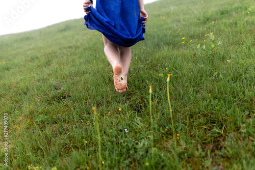 Cropped view of beautiful young woman walking in forest barefoot