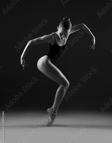 Ballerina in black leotard in a geometric pose. Black and white photo. © Yevgeniy