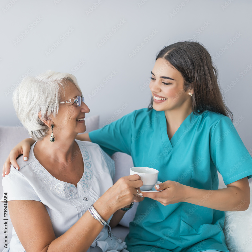 Happy senior woman talking with friendly nurse at geriatric ward Happy senior woman talking with friendly nurse at geriatric ward