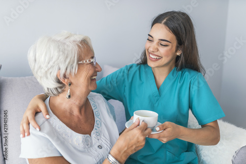 фотографія Happy senior woman talking with friendly nurse at geriatric ward