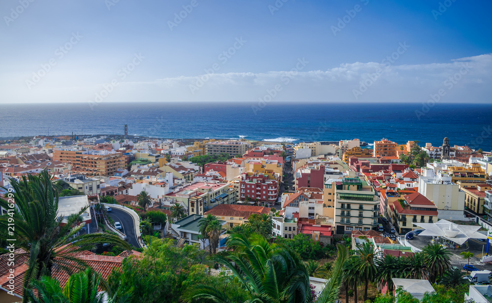 Fototapeta premium Puerto de la Cruz cityscape with Atlantic ocean background and blue sky with sunset light, Tenerife, Canary islands, Spain