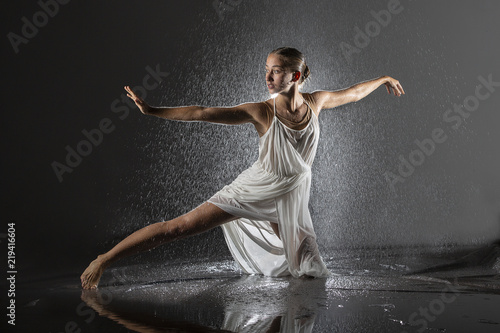 Mujer joven haciendo danza contemporánea con ducha en estudio photo