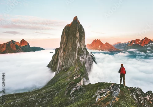 Obraz Podróżnik wędrujący po górach grzbiet ponad chmurami przygoda podróż podróż na świeżym powietrzu w Norwegii aktywne wakacje zachód słońca góra Segla