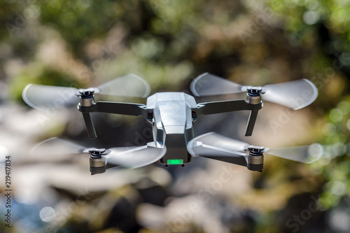 flying quadrocopter on a background of green foliage, close-up