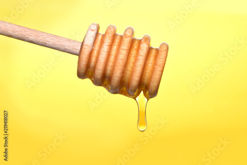 Konstfotografi Honeyspoon closed up isolated on yellow