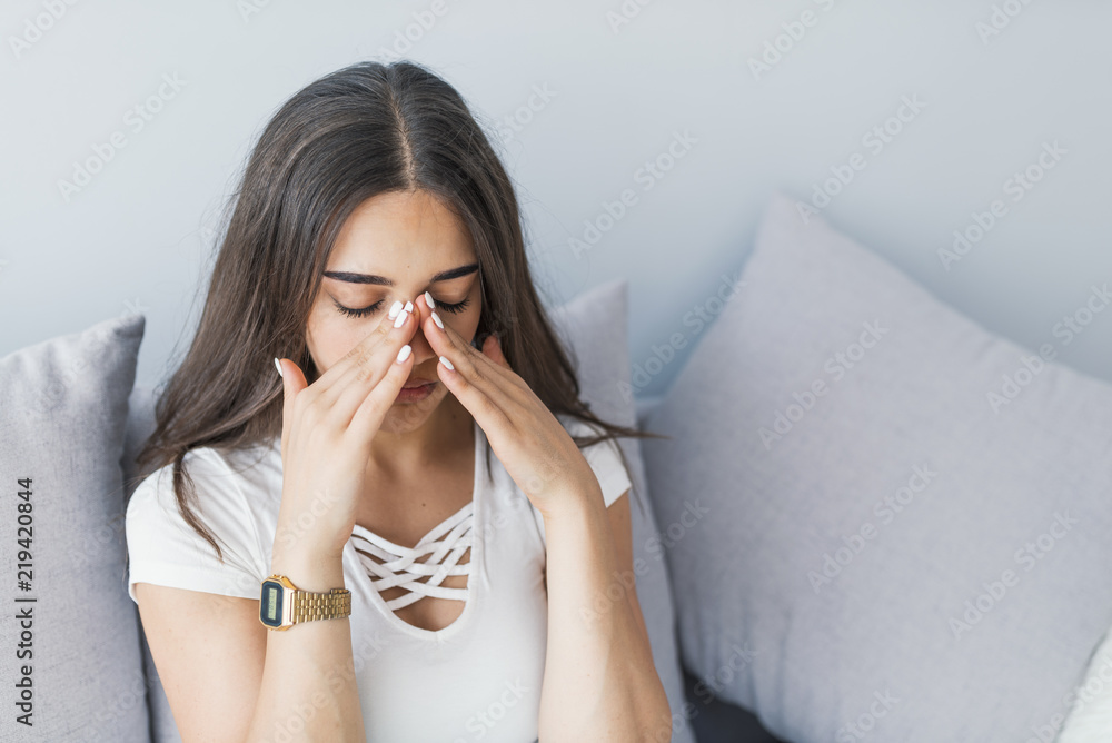Sinus pain, sinus pressure, sinusitis. Sad woman holding her nose and head because sinus pain. Sinus ache causing very paintful headache. Sinus pain, sinus pressure, sinusitis. Sad woman holding her nose and head because sinus pain. Sinus ache causing very paintful headache.