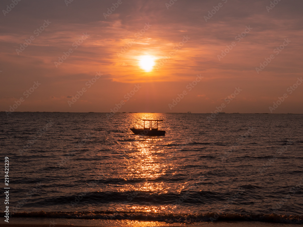 Boat floating in the sea during sunset.
