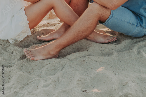feet of a young couple in love barefoot, on the sand