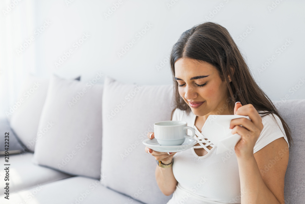 Cold. Closeup Of Beautiful Young Woman With Hot Cup Of Tea In Hands. Sickness And Illness. Portrait Of Sick Unhealthy Female Drinking Warming Yellow Drink Indoors. High Resolution