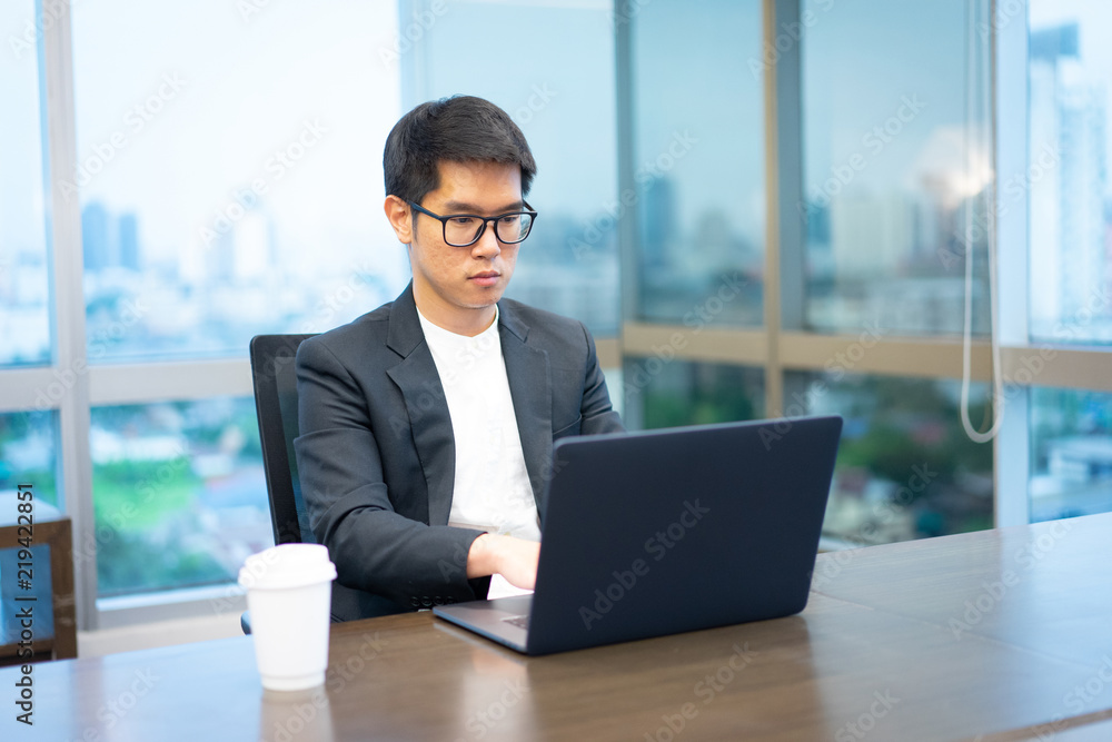 a businessman is working seriously with his laptop computer. a businessman is working seriously with his laptop computer.