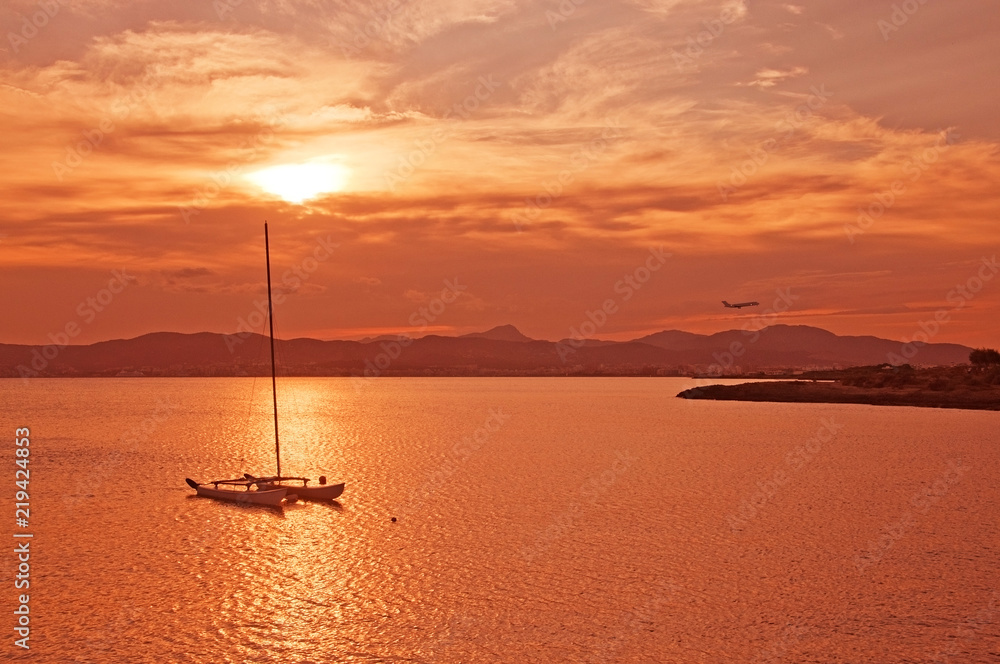 Beautiful sunset view over Palma bay with moored sailboat on a sunny summer evening in July, Mallorca, Spain.
