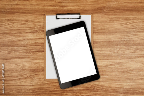 Digital tablet with blank screen and clipboard with white sheet on wooden background