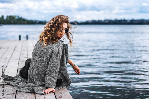 Cute girl with curly hair relaxing near lake © bedya