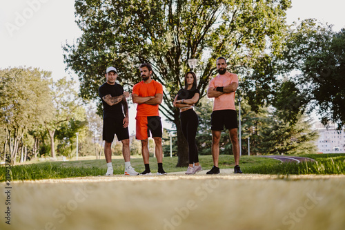 Group of fit people standing in the park and posing
