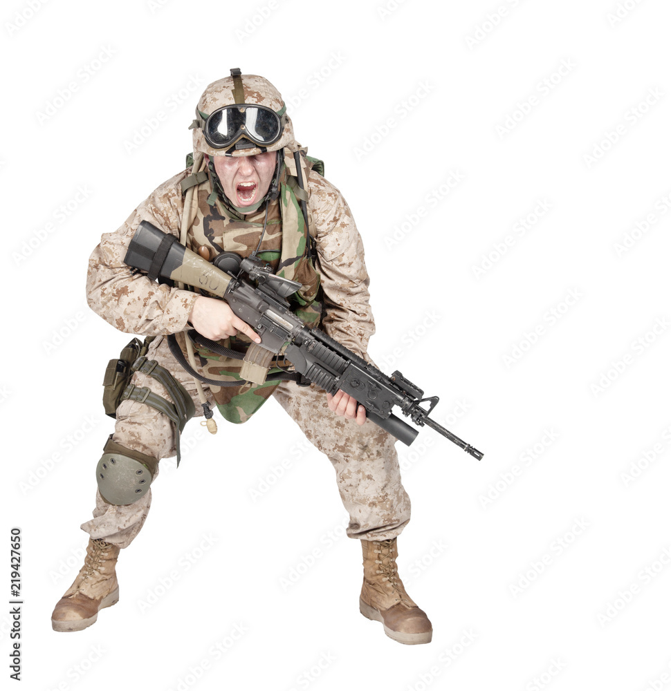 Studio shoot of modern infantry soldier, U.S. marine rifleman in combat uniform, helmet and body armor, screaming and crouching down with assault service rifle in hands isolated on white background Studio shoot of modern infantry soldier, U.S. marine rifleman in combat uniform, helmet and body armor, screaming and crouching down with assault service rifle in hands isolated on white background