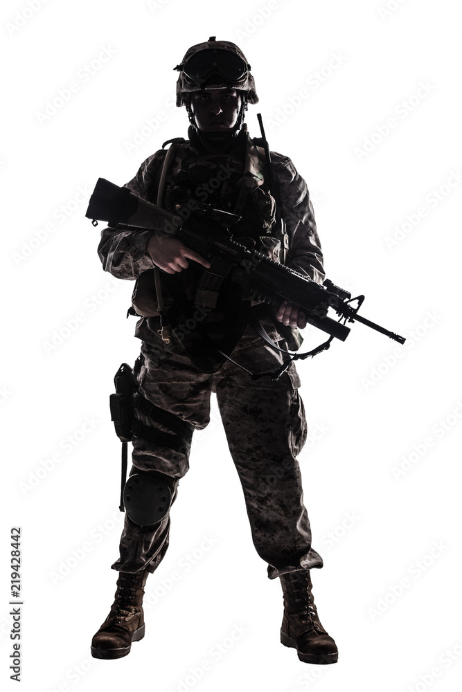 Full length, low key studio shoot of fully equipped army soldier in camo uniform and helmet, armed with pistol and assault service rifle with underbarrel grenade launcher isolated on white background Full length, low key studio shoot of fully equipped army soldier in camo uniform and helmet, armed with pistol and assault service rifle with underbarrel grenade launcher isolated on white background