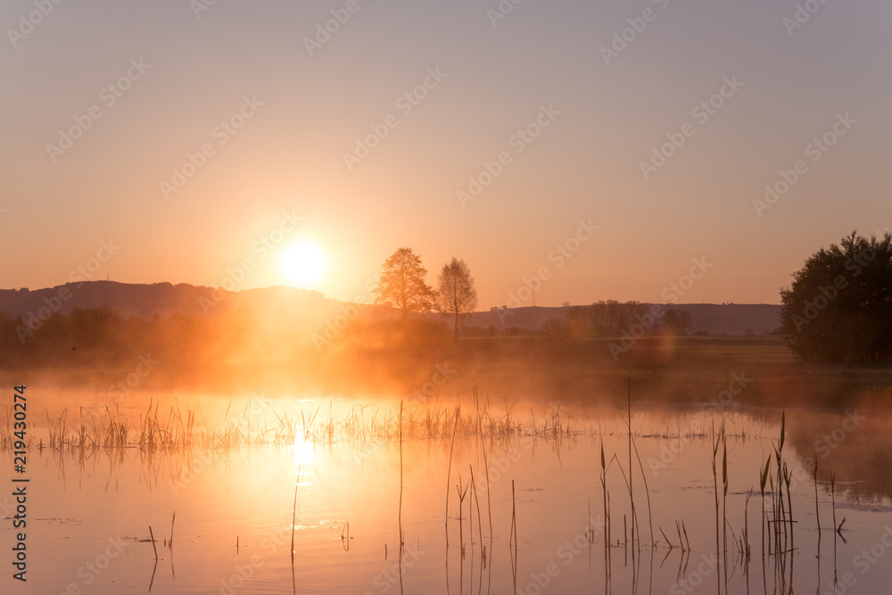 Obraz premium Misty Golden Sunrise Reflecting over Lake in Spring.